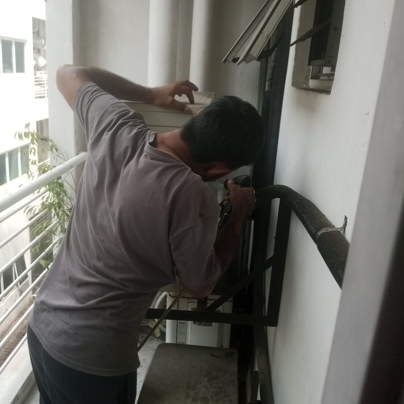 Professional technician doing regular aircond maintenance service KL