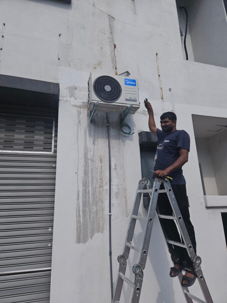 Technician using digital meter for aircond compressor repair and outdoor diagnosis