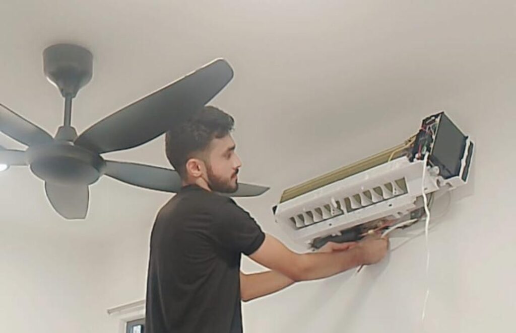 Expert technician checking indoor unit for aircond not cooling issue