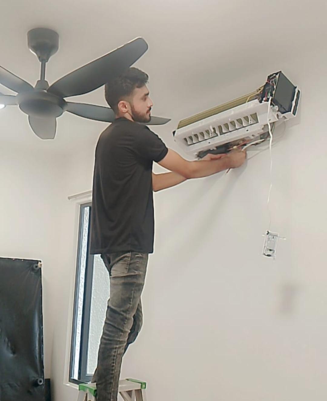 Professional technician troubleshooting indoor unit for aircond repair service KL